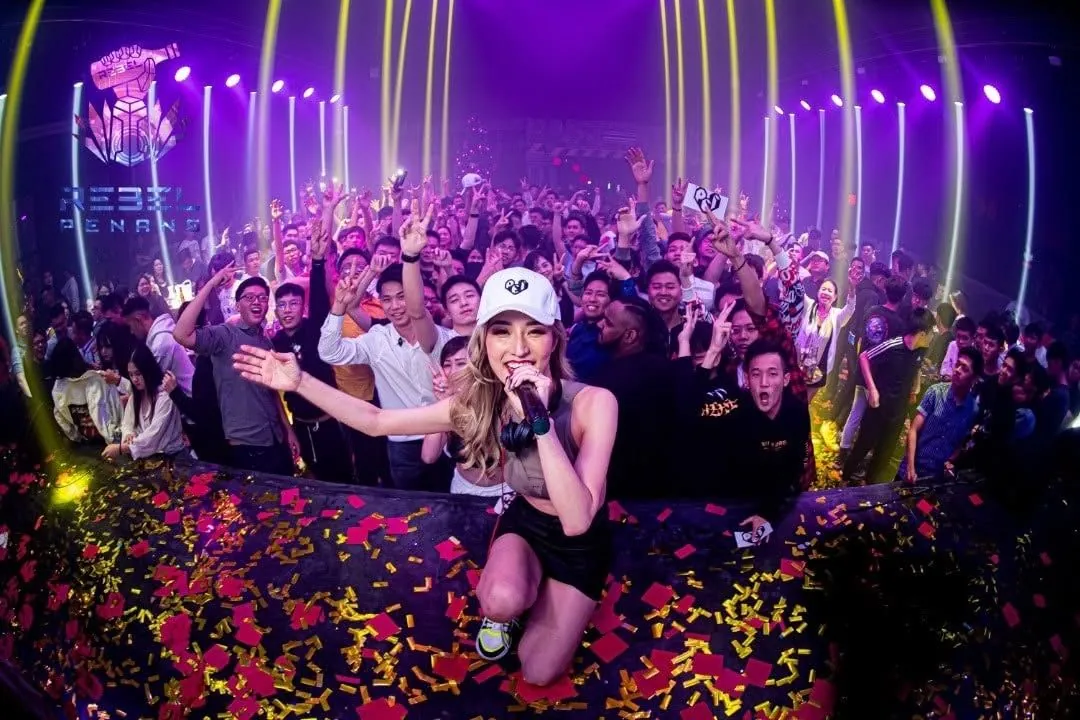Packed floor at Rebel Penang with confetti and neon tube lighting