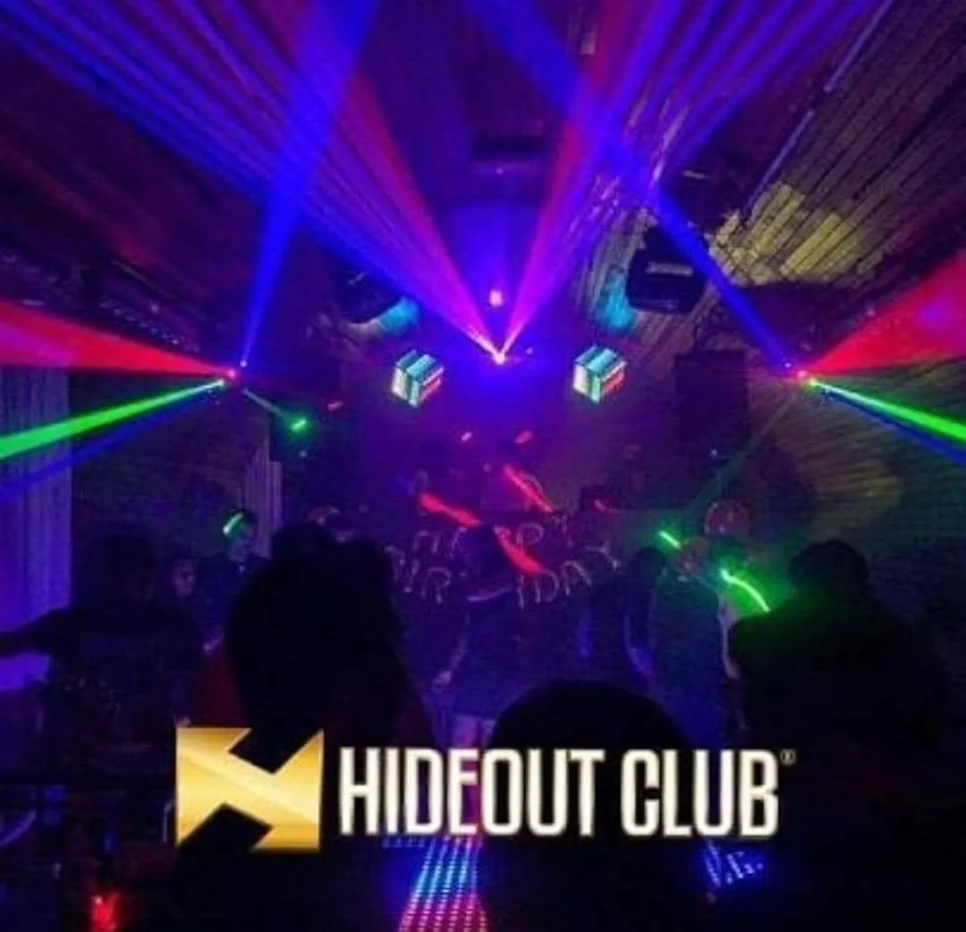 Hideout Club dance floor under laser beams with the Hideout Club logo